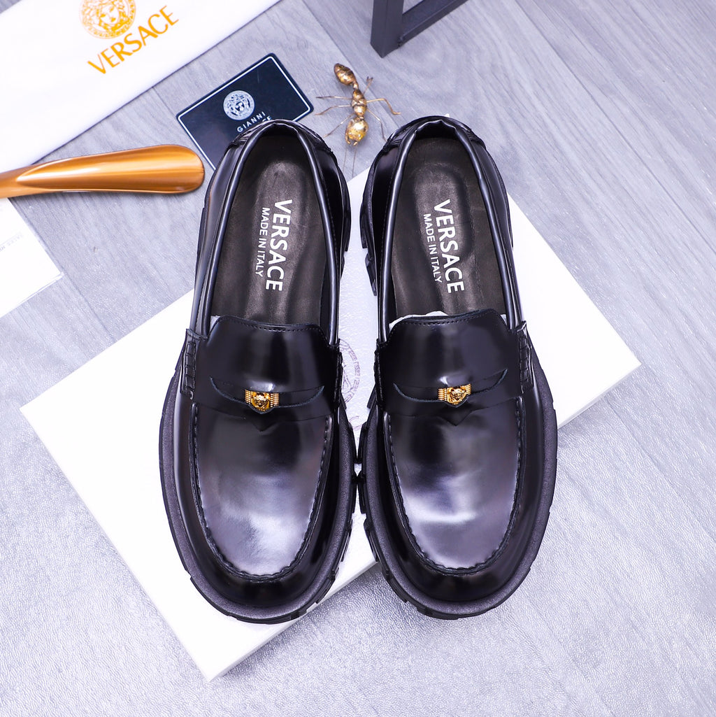 Black Versace leather loafers with gold emblem and chunky lug sole, pair front view