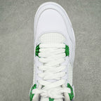 White sneaker upper close-up with green lace cover and mesh tongue