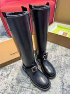 Pair of black knee-high boots with buckled strap details and textured cuff lining