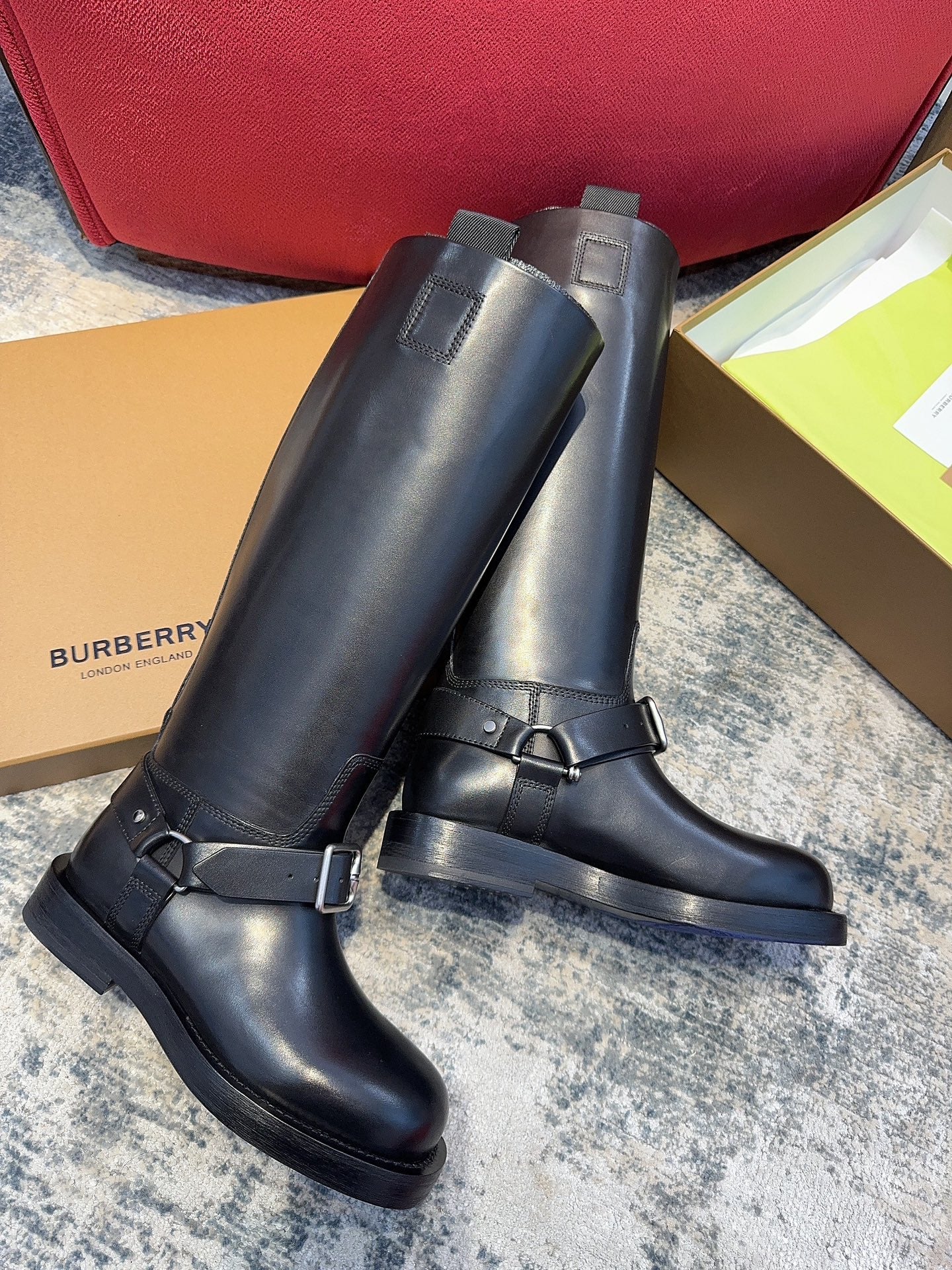 Black knee-high boots with adjustable buckle straps and low-profile rubber soles