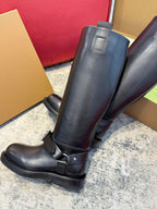 Black knee-high boots with side buckle straps and smooth leather upper