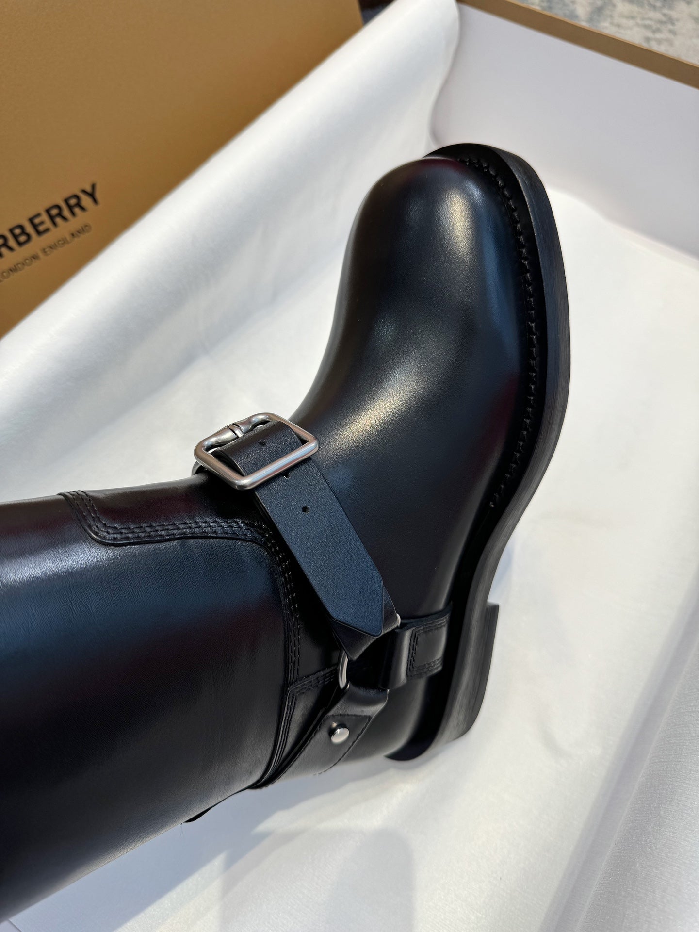 Black knee-high boot upper with side buckle strap and smooth leather finish