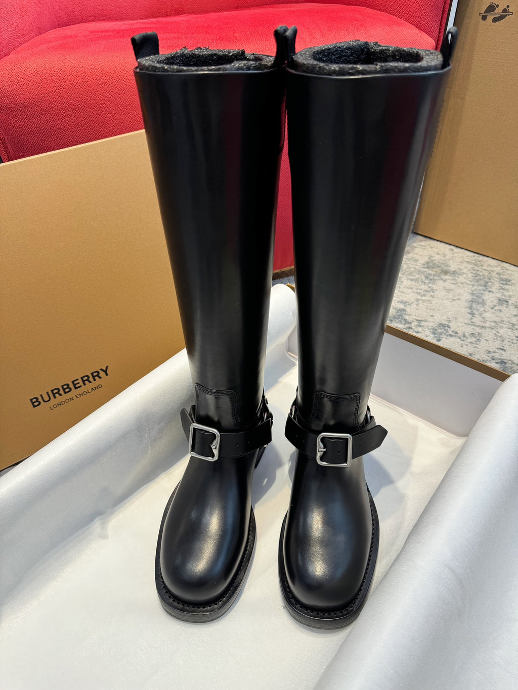 Black knee-high leather boots with double buckled straps and chunky soles
