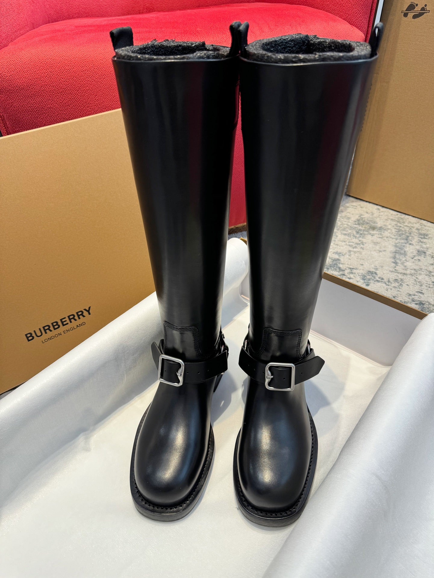 Black knee-high leather boots with double buckled straps and chunky soles