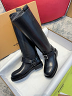 Black knee-high riding boots with side buckles and textured rubber outsoles