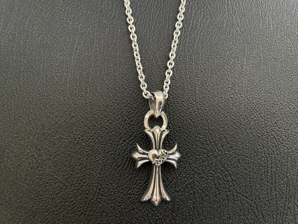 Silver-tone cross pendant necklace with flower-like centerpiece and open bail loop