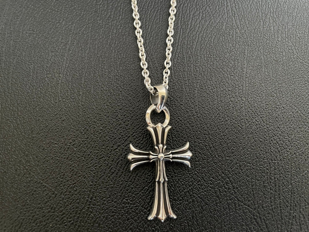 Silver-tone cross pendant necklace with long vertical center and flared arm tips
