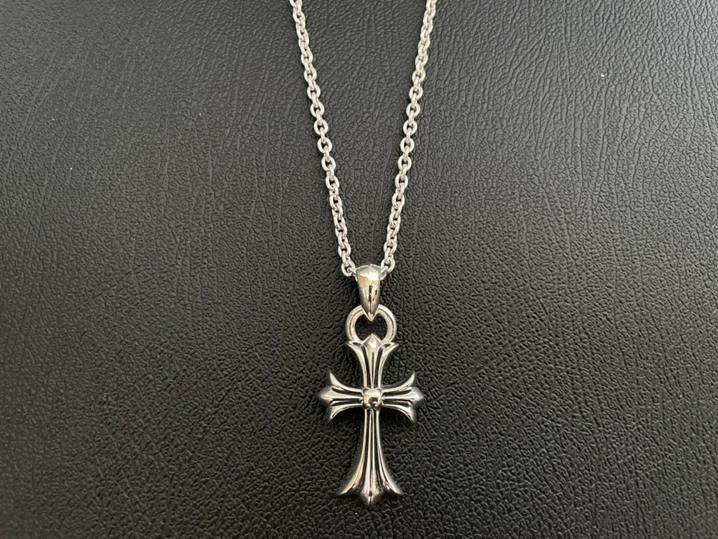 Silver-tone cross pendant necklace with four-point arms and heart-shaped top bail