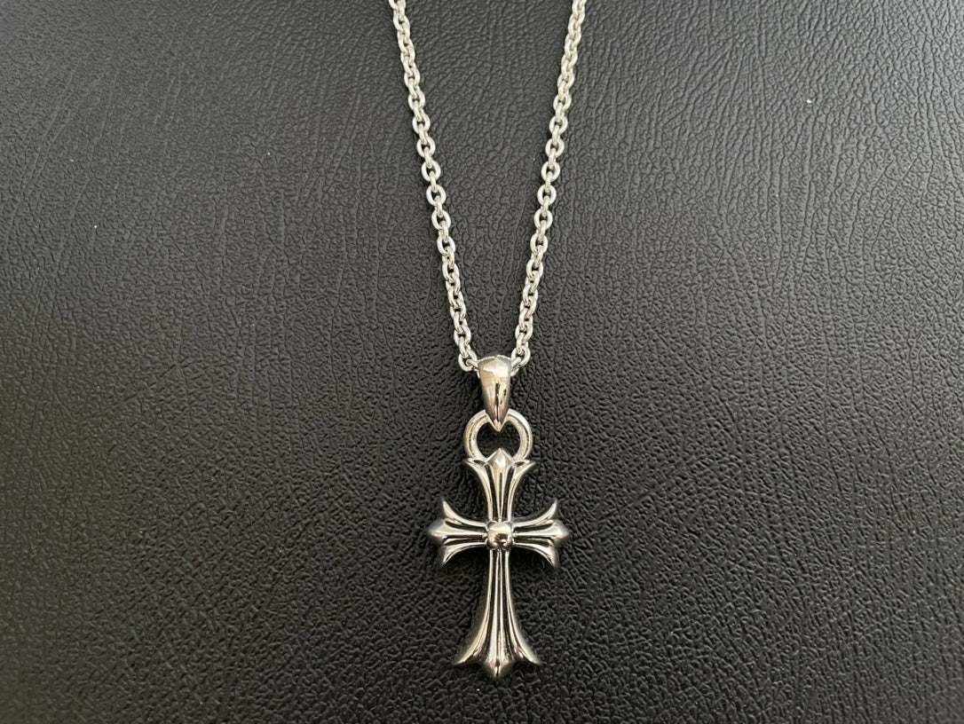 Silver-tone cross pendant necklace with four-point arms and heart-shaped top bail