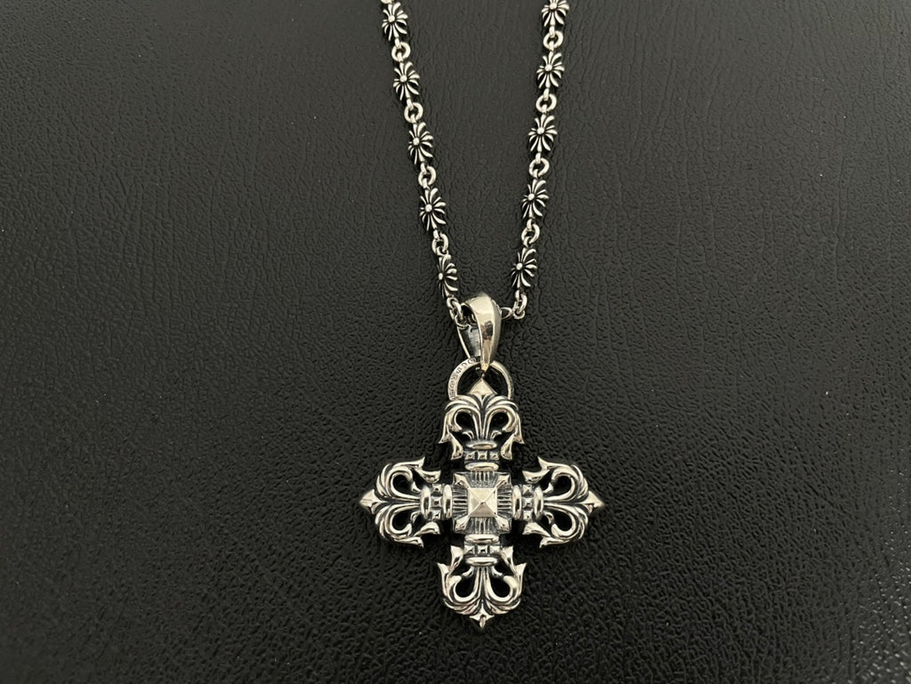 Silver-tone ornate cross charm necklace with scroll details on double chain.