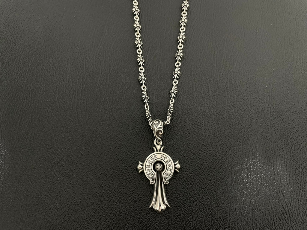 Silver-tone round medallion charm necklace with cross-like hanging pendant on double chain.