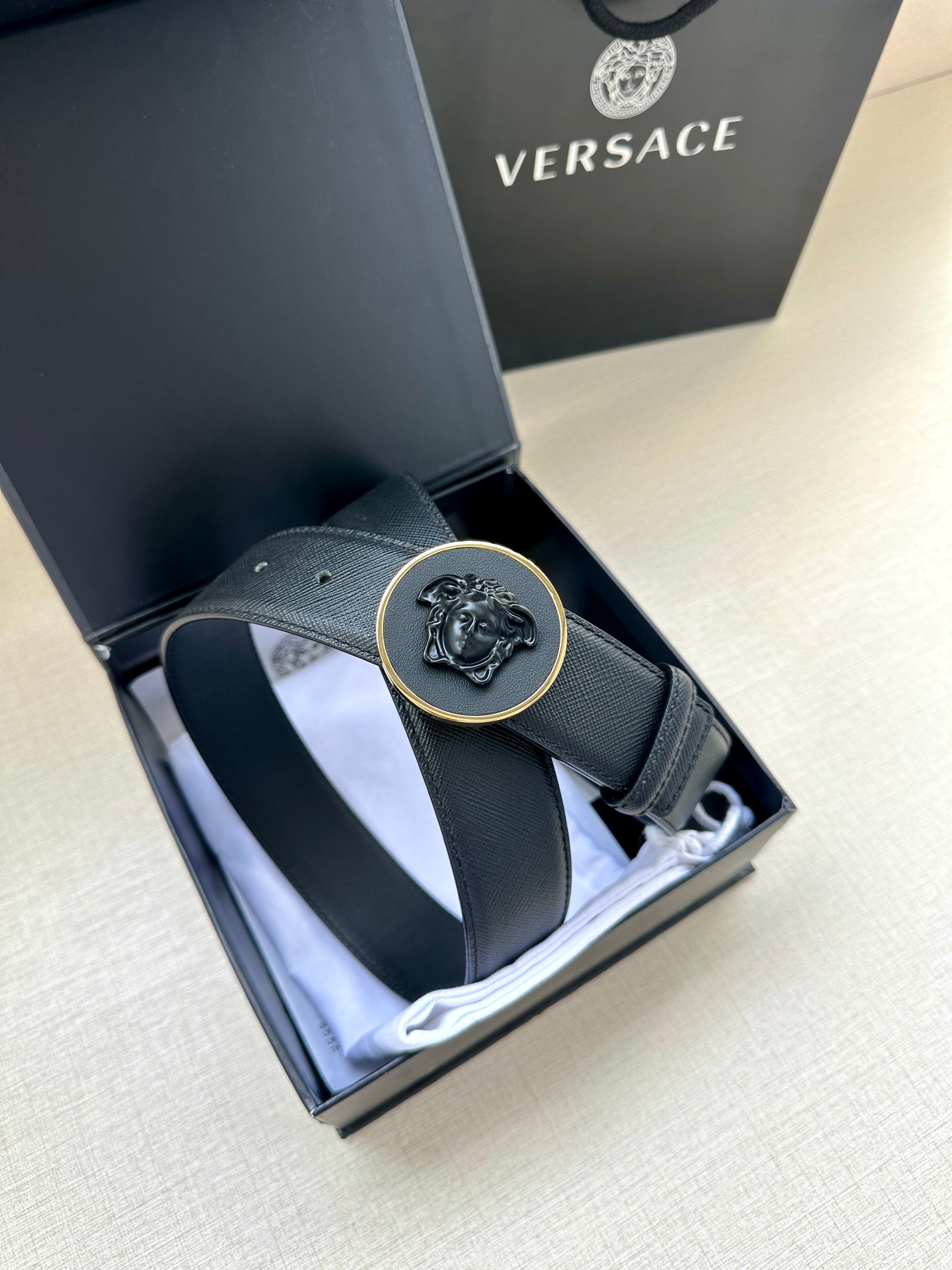 Versace dark blue leather belt laid in box, round Medusa buckle centered