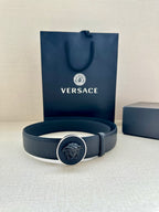 Versace belt laid flat with gold-tone emblem buckle and dark blue strap