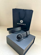 Versace belt displayed with dark blue strap and round emblem buckle