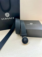 Dark blue belt shown with round logo buckle and textured strap edge stitching