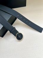 Dark blue leather-look belt with round logo buckle and multiple punched holes
