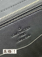 Louis Vuitton logo on dark leather zip pouch with silver-tone zipper, close-up.