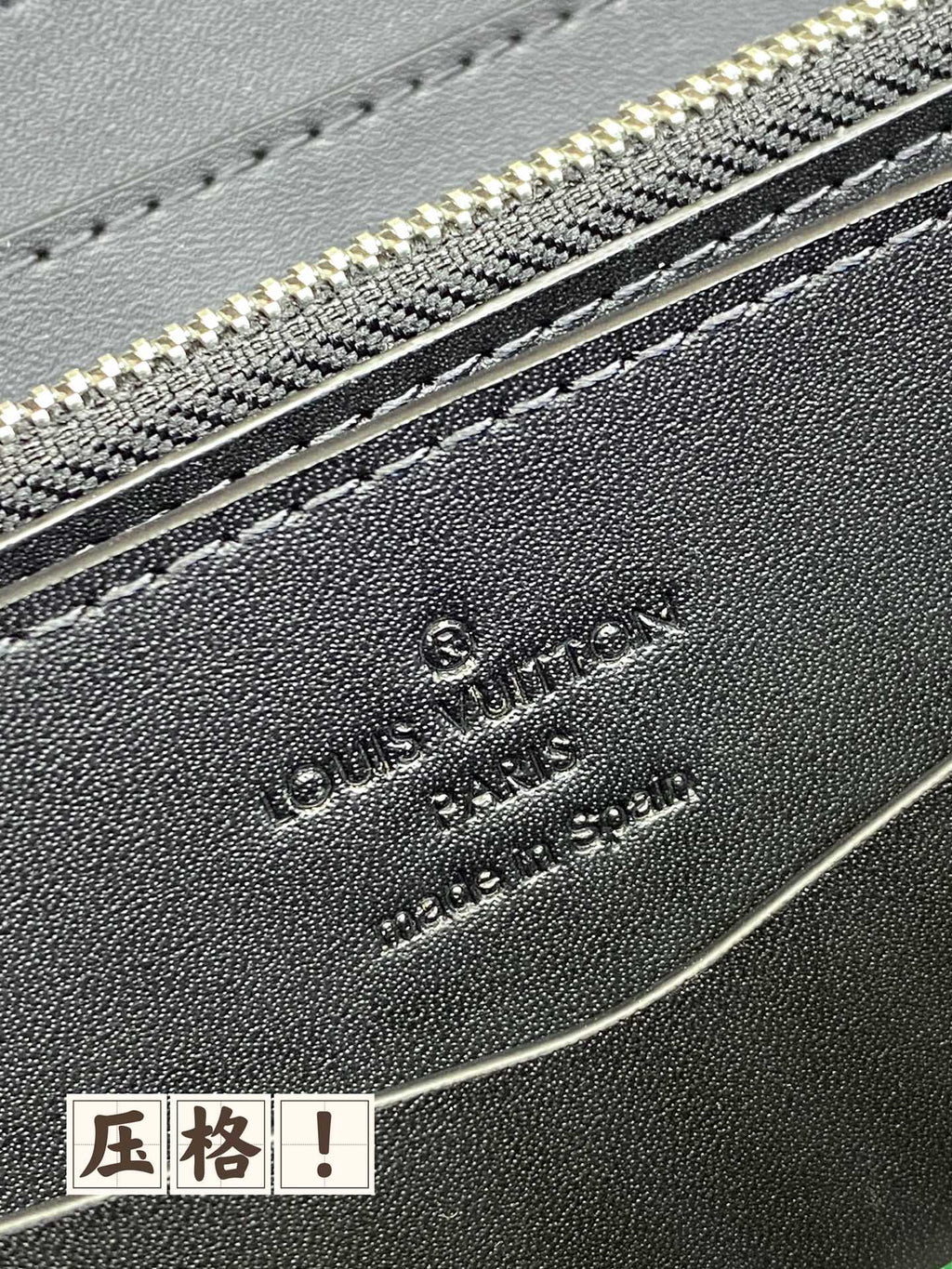 Louis Vuitton embossed logo on dark blue leather with silver zipper teeth