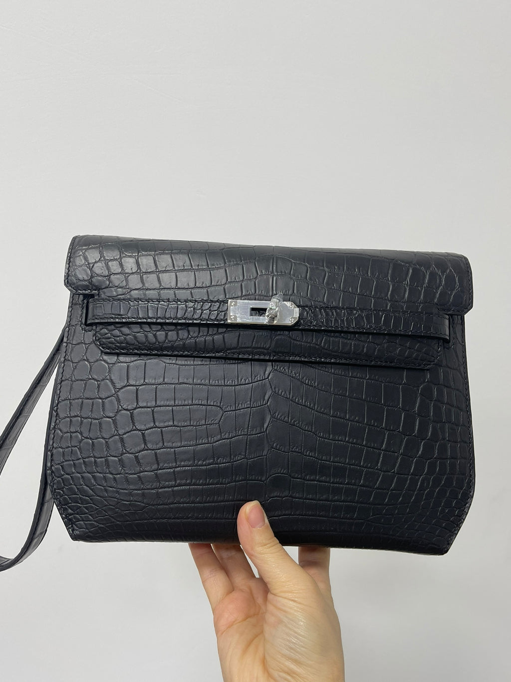 Hermes bag in dark crocodile-embossed leather, front flap with silver clasp and strap