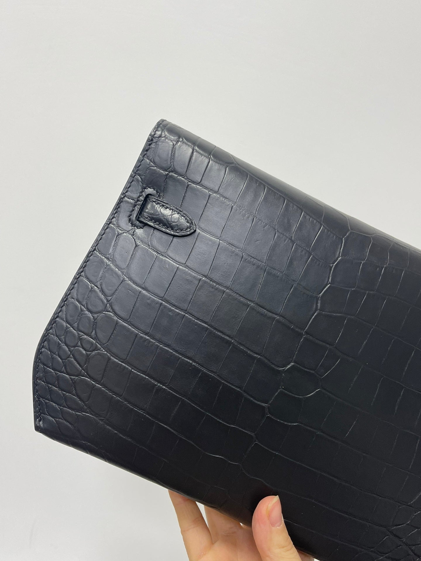 Hermes bag side, croc-textured dark leather, curved top flap with stitched edges
