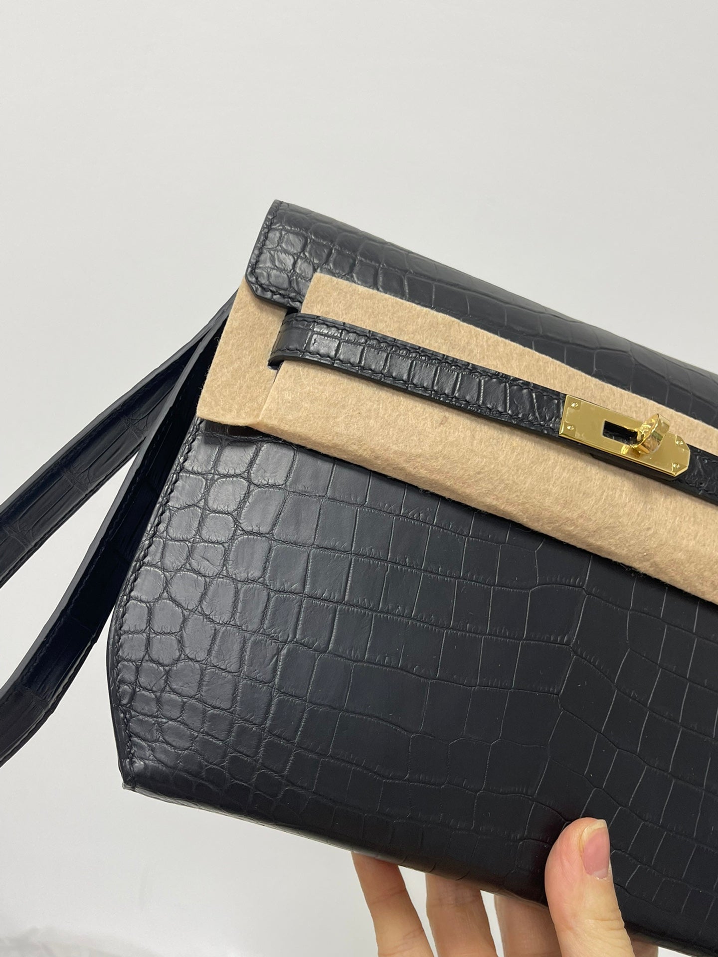 Hermes bag close-up, croc flap with gold lock, beige trim, shoulder strap