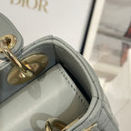Dior handbag interior side panel with stitched light blue-gray leather and gold details.
