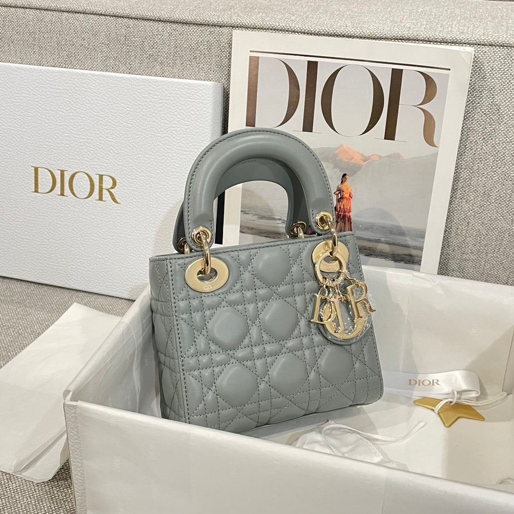 Dior quilted mini handbag with top handles, light blue-gray leather and gold rings.