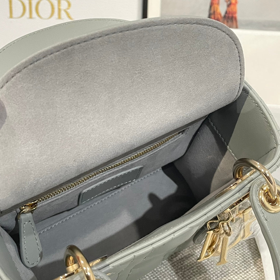 Dior handbag interior with zip opening, light blue-gray leather and gold zipper trim.