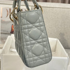 Dior quilted mini handbag back view with strap, light blue-gray leather and gold hardware.
