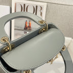 Dior mini handbag with top handle and side strap, light blue-gray leather, gold hardware.