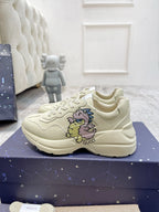 Gucci unisex luxury shoes: cream lace-up sneakers with unicorn graphic, front angle