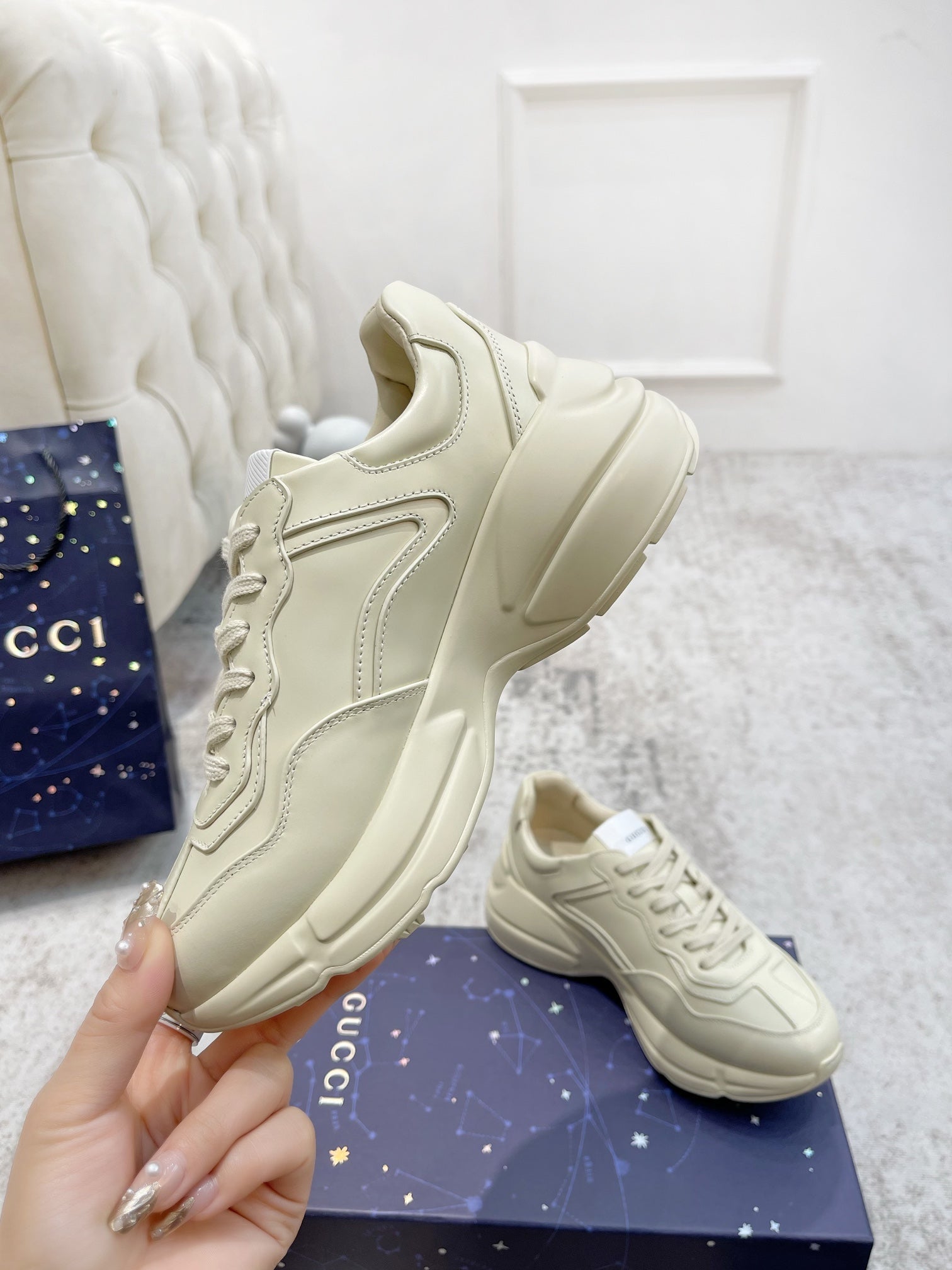 Gucci unisex luxury shoes: cream sneaker close-up with stitched panels and laces