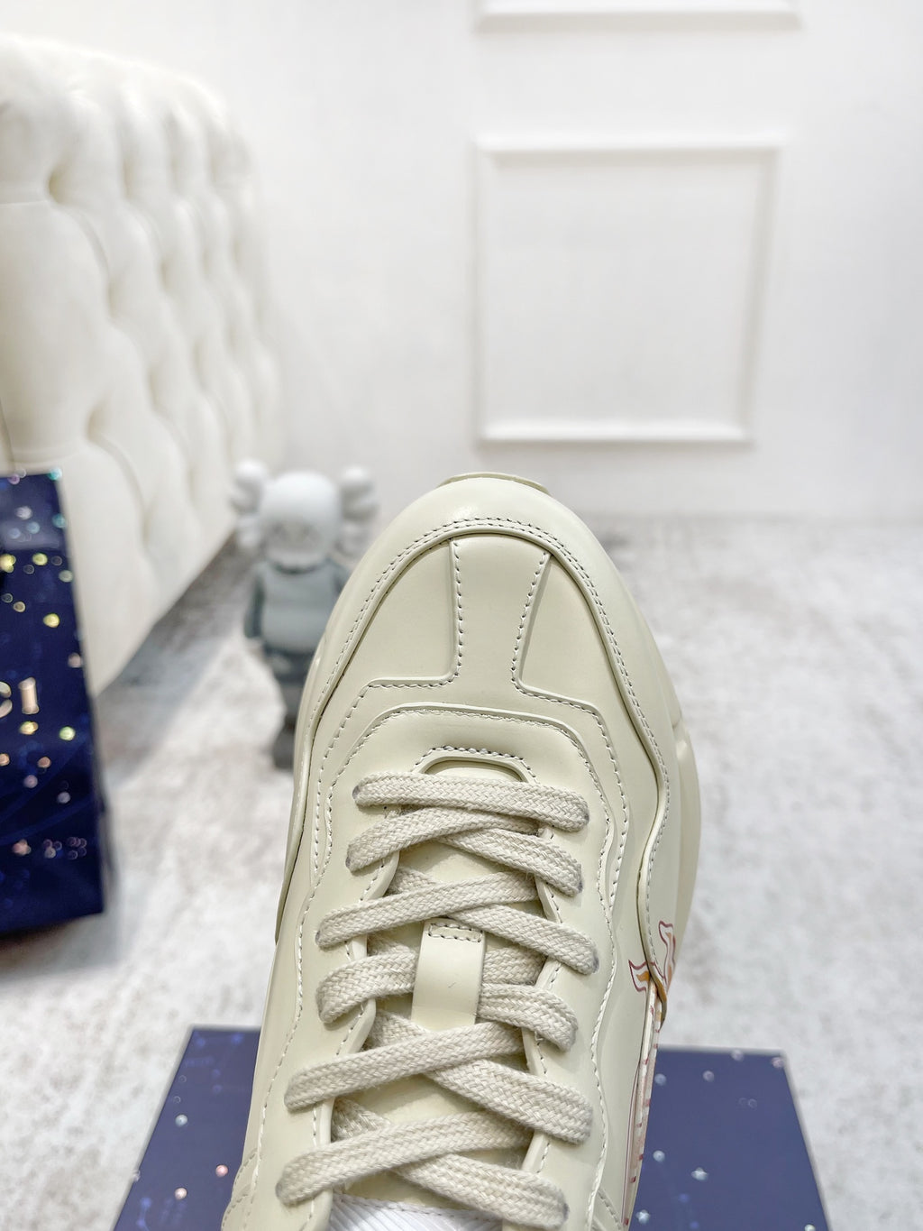 Gucci unisex luxury sneakers, light cream upper close-up with laces and stitching details