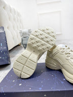 Cream Gucci unisex sneakers showing outsole tread on blue box