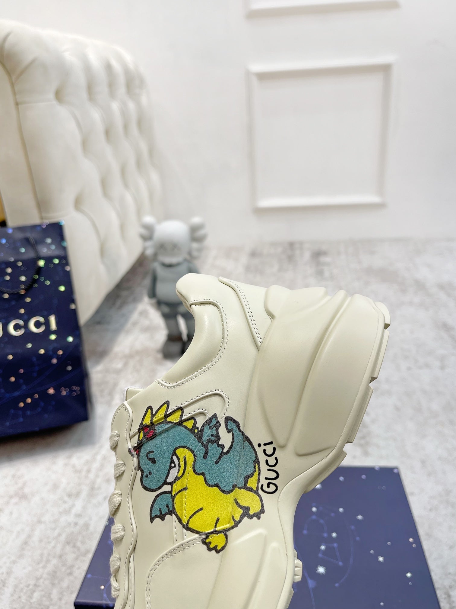 Cream Gucci unisex slip-on style sneaker with cartoon graphic on side