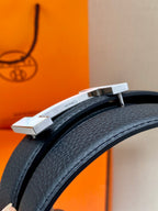Hermes belt buckle detail with silver H hardware on dark leather strap