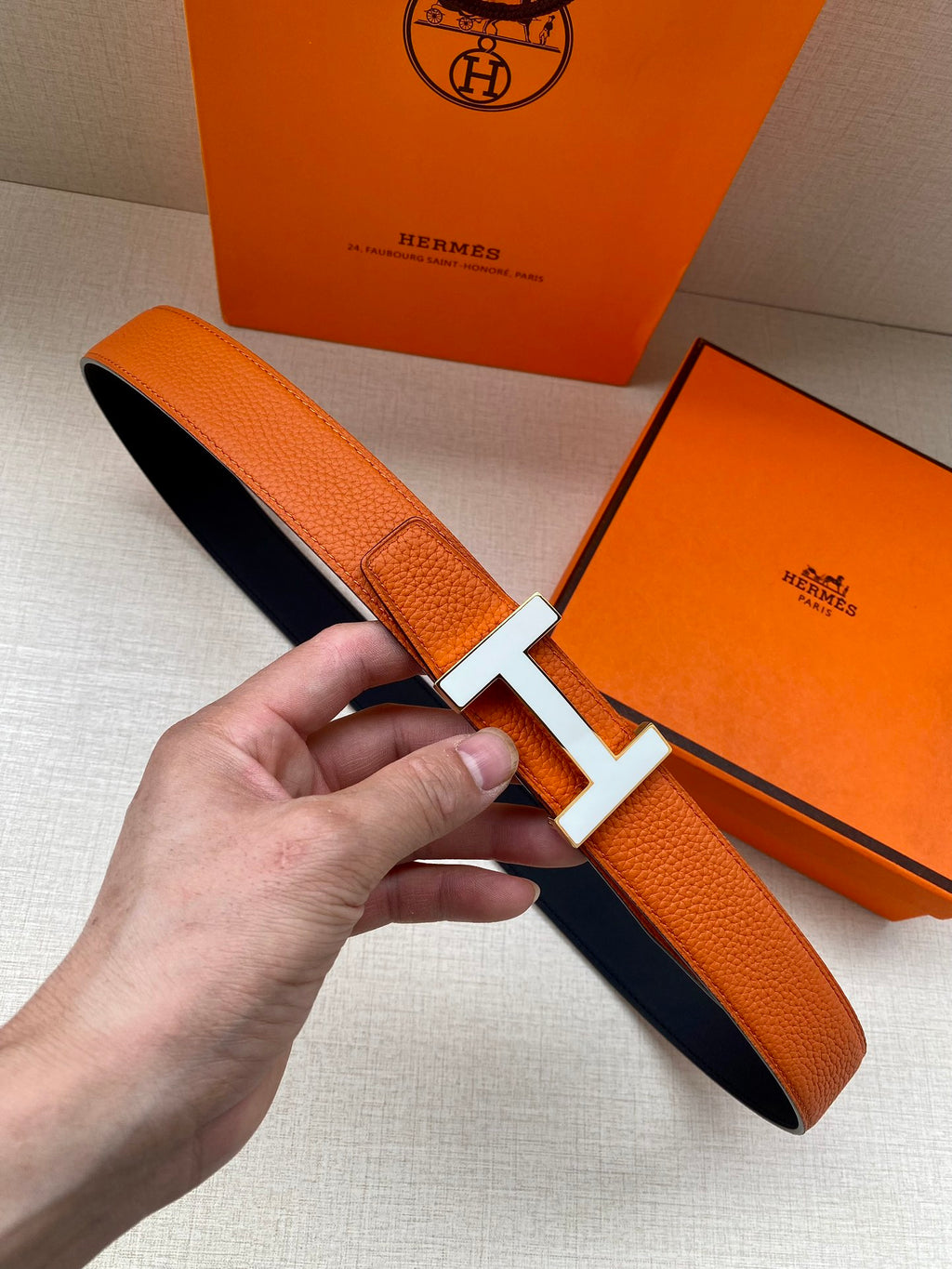 Hermes belt in orange textured leather with silver H buckle, single keeper strap
