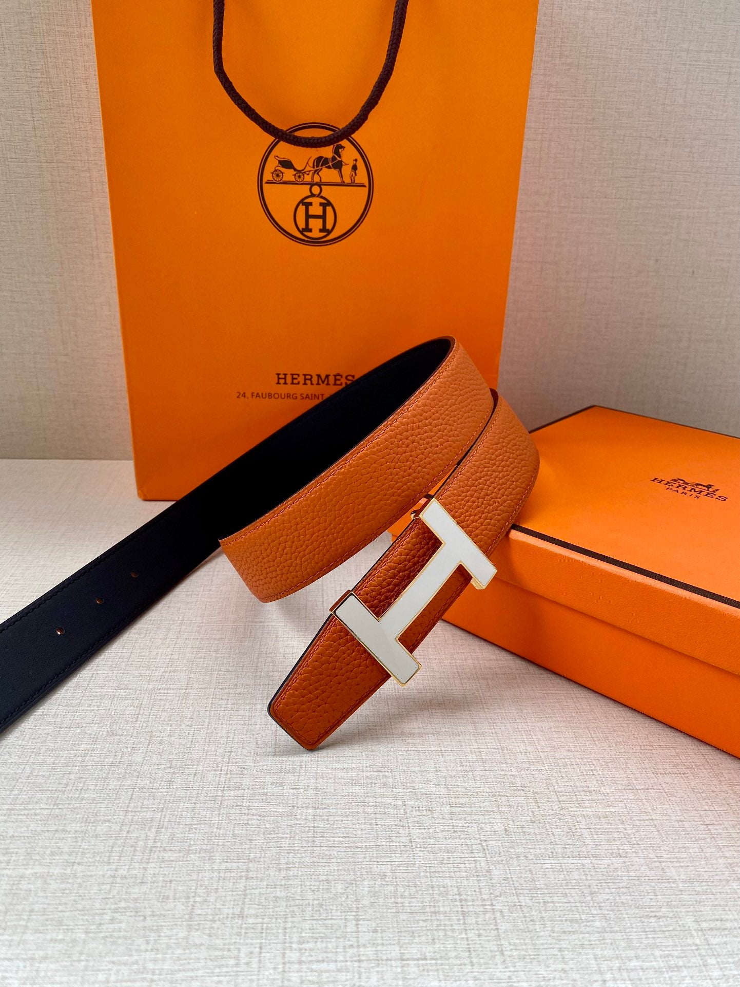 Hermes belt with orange leather and silver H buckle, hanging length with keeper