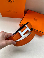 Hermes belt buckle close-up: orange leather with silver H and center bar
