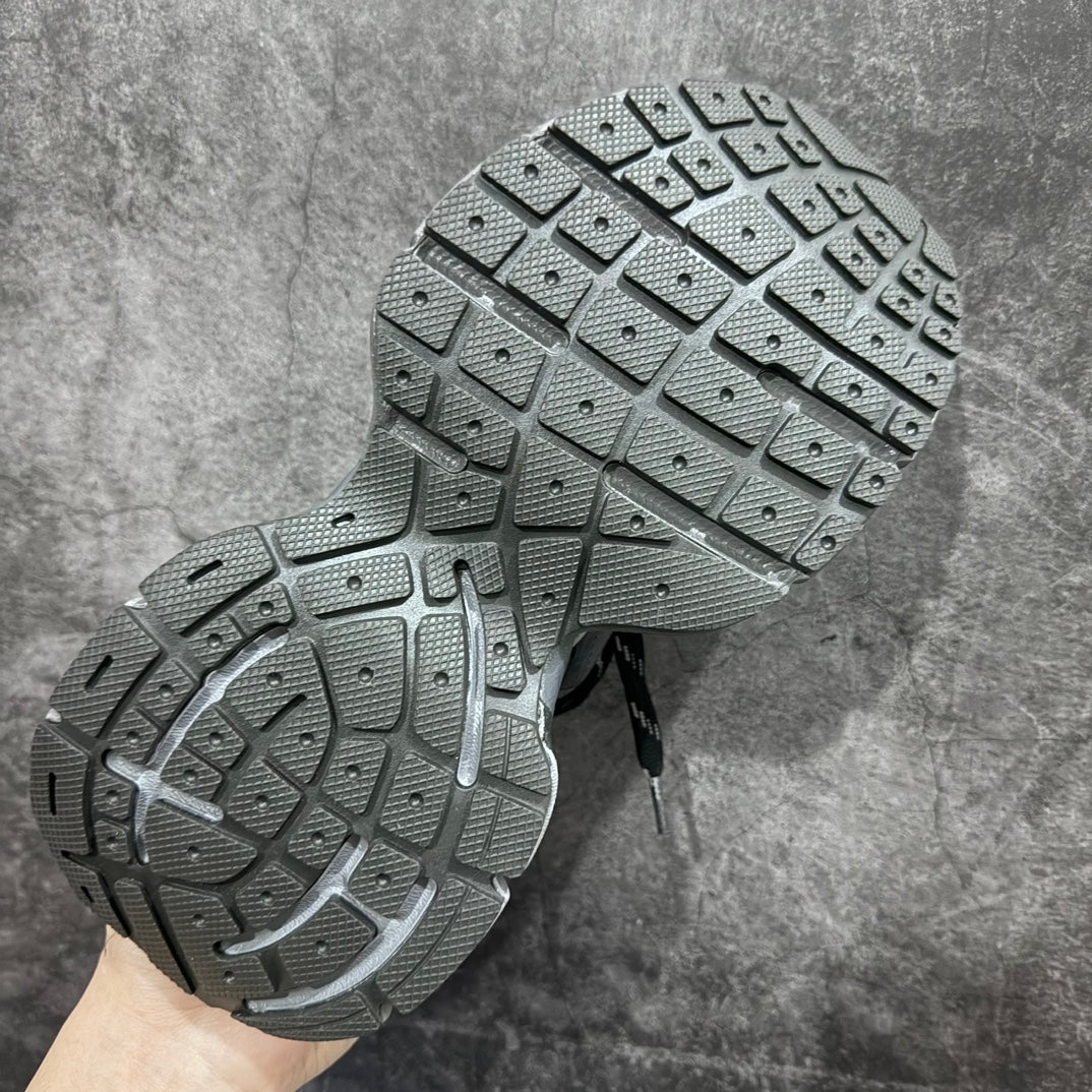 Shoe outsole with deep rubber tread, showing two gray soles held up