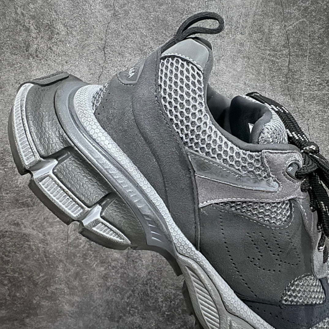 Gray athletic sneaker side view with mesh quarter, black laces, and raised sole