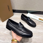 Black leather loafers with strap detail, shown in hand with rounded toe