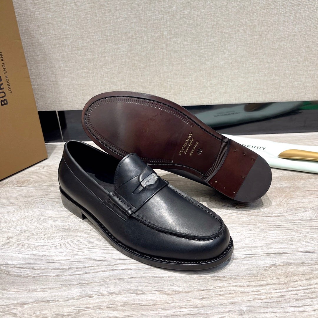 Black leather loafers with strap detail, visible insole and sole underside