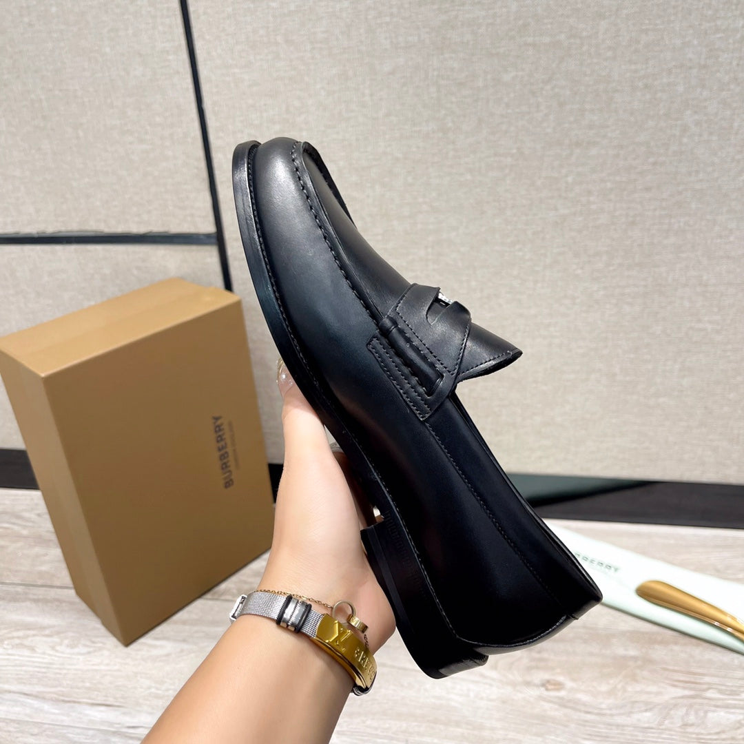 Black leather loafer with strap across vamp, side view, stitched edges