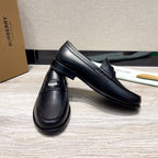 Pair of black leather loafers with strap detail and stitched apron, low profile