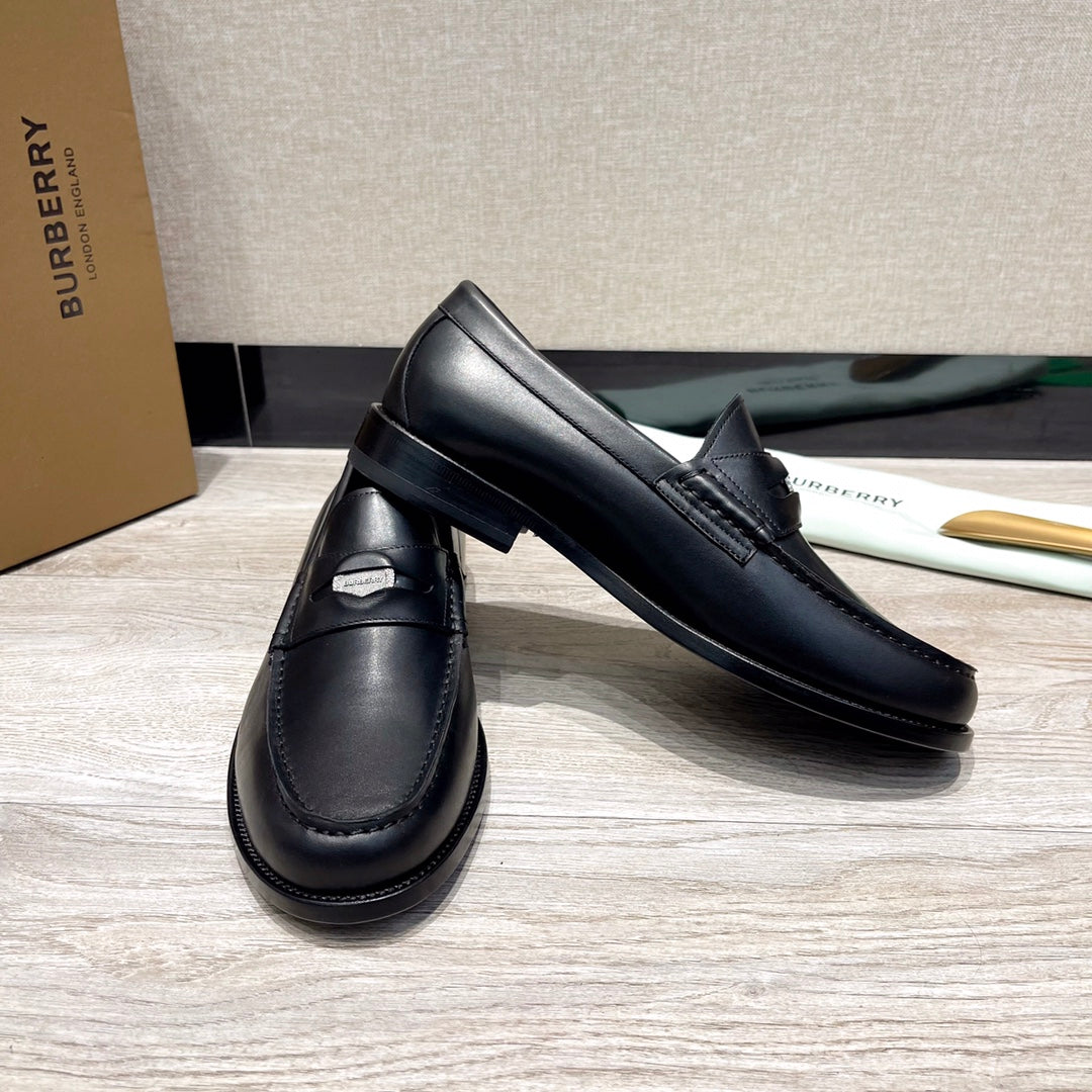 Pair of black leather loafers with strap detail and stitched apron, low profile