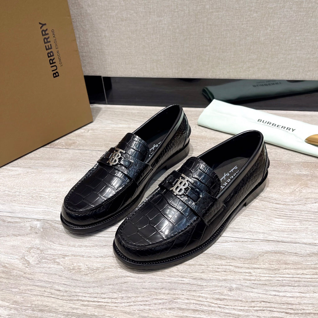 Black leather loafers with embossed texture and metal buckle detail