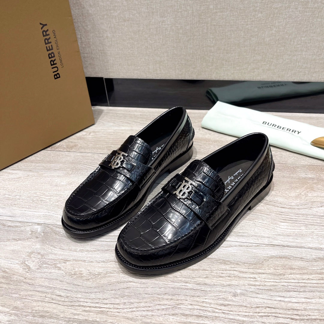 Black leather loafers with embossed texture and metal buckle detail