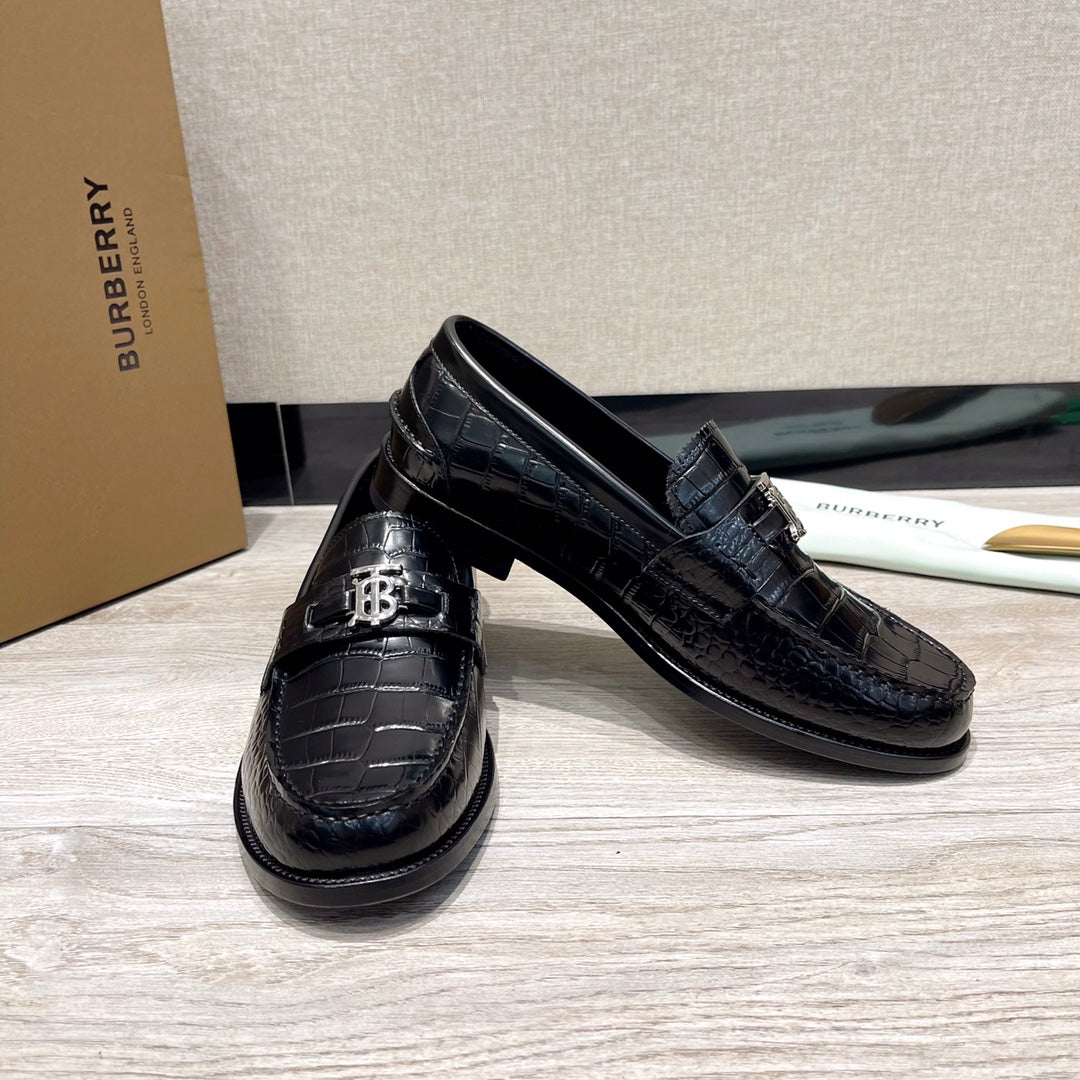 Black leather loafers with embossed pattern and branded metal buckle