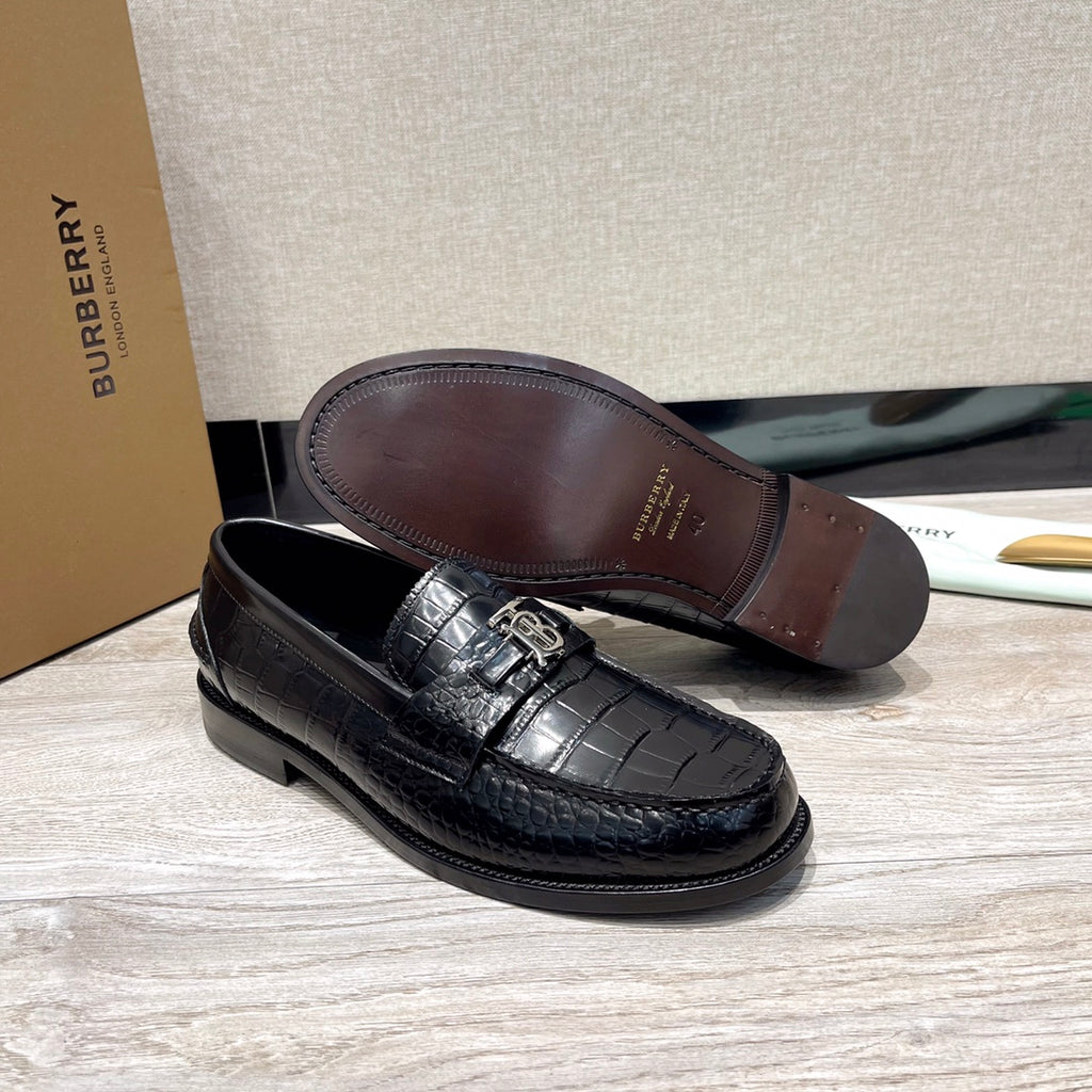 Black leather loafer with embossed texture and metal buckle, brown outsole